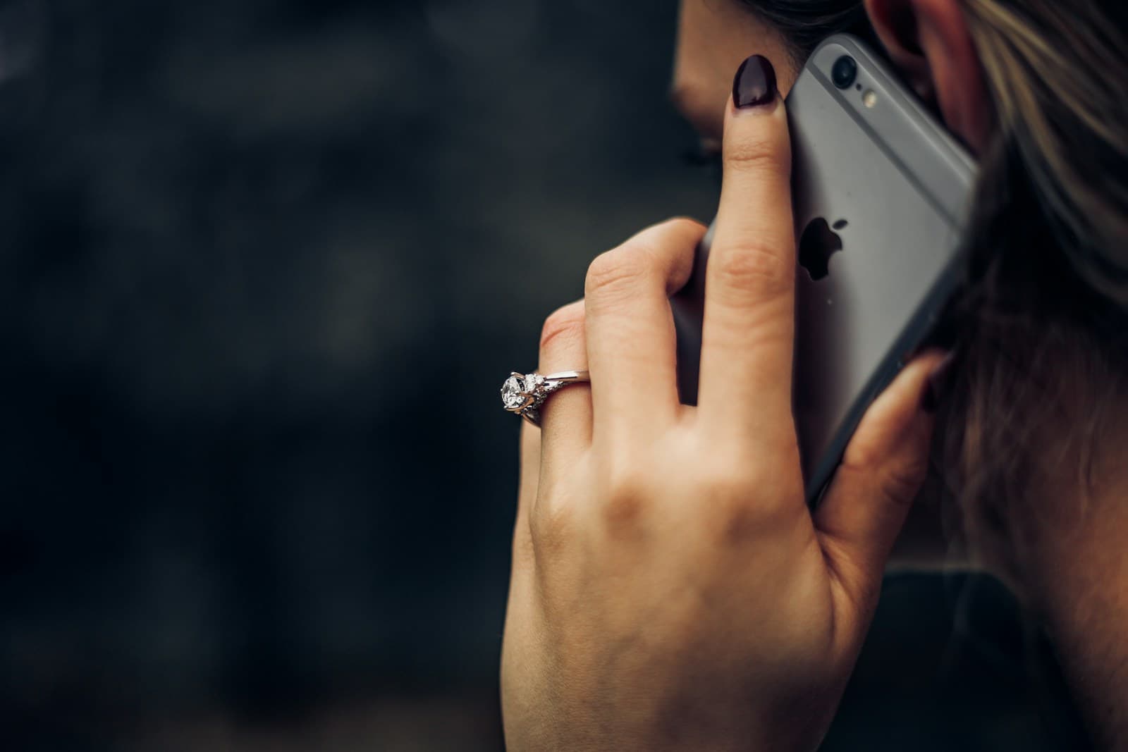 Woman holding a white smartphone to her ear during a call
